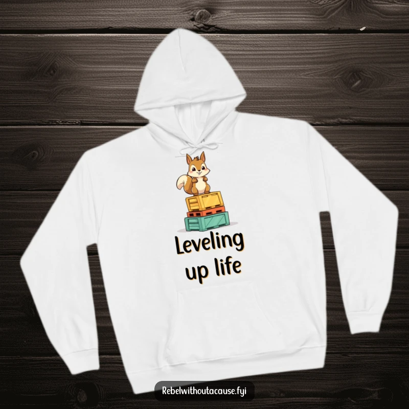 Funny Squirrel Victory Hoodie: A fearless squirrel character stands proudly atop overturned crates, conveying strength and pride.