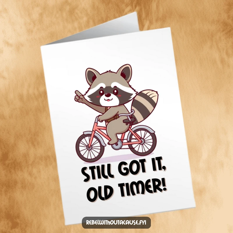 Funny Free Printable Birthday Card: Kawaii raccoon in a cheeky salute rides a tiny bicycle backwards, spreading birthday cheer.